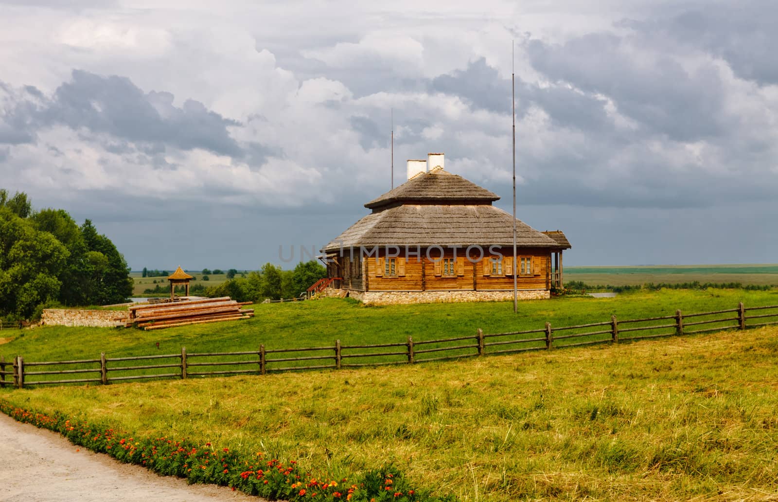 wooden cottage on green hill under cloudy sky