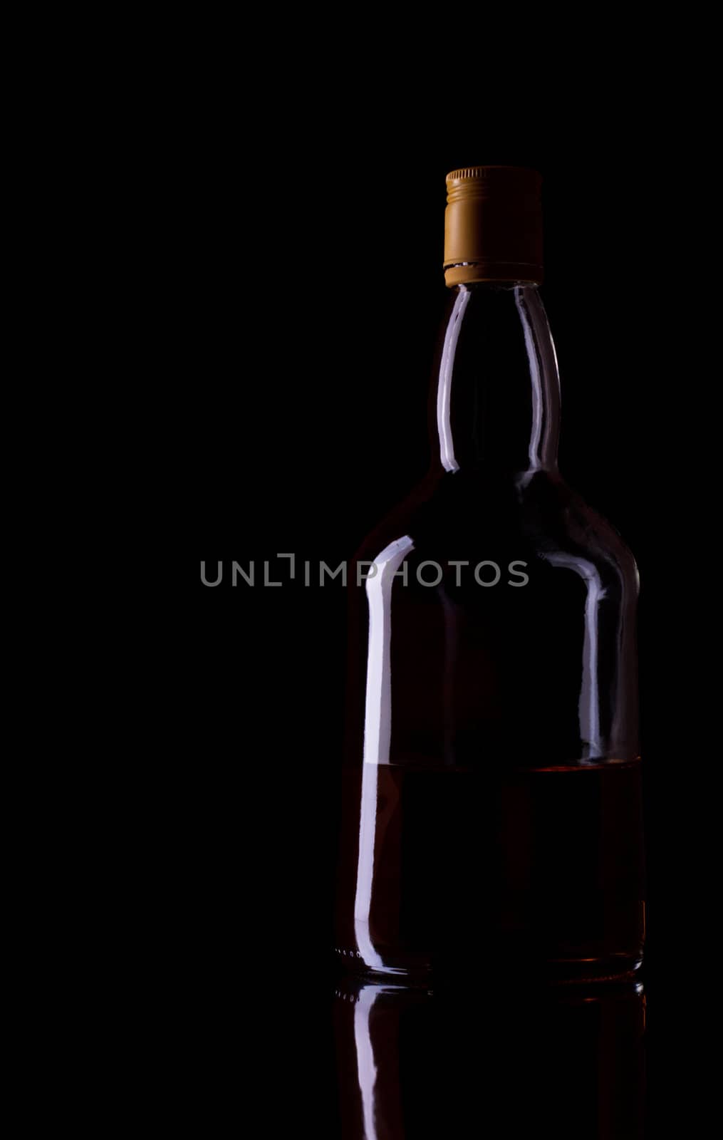 empty whiskey bottle isolated on black background