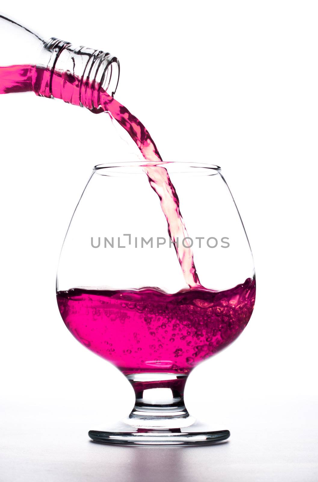 coсktail pour into the glass over white background