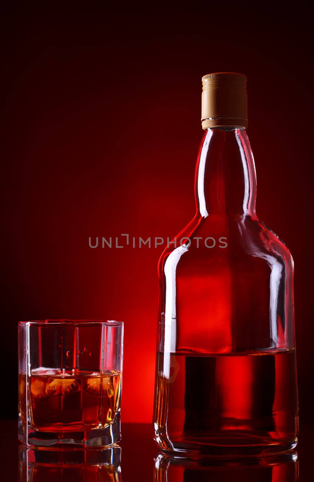 whiskey bottle and glass on red background