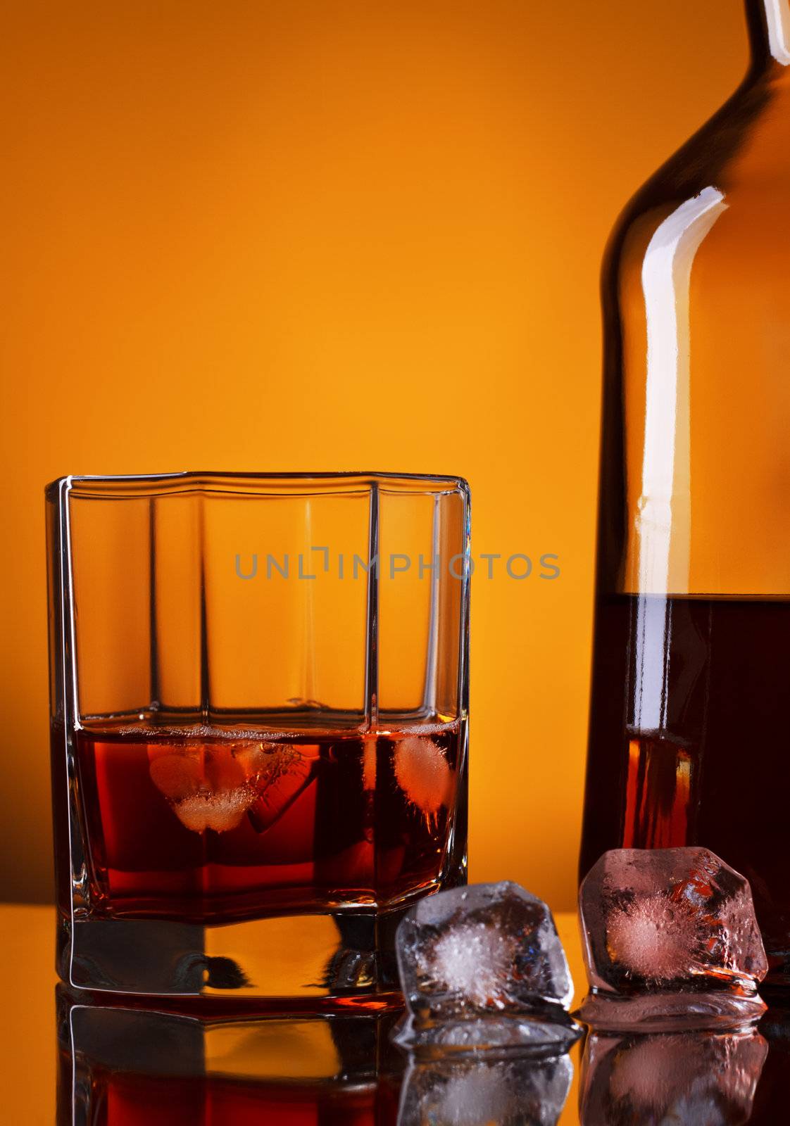 whiskey bottle and glass on yellow background