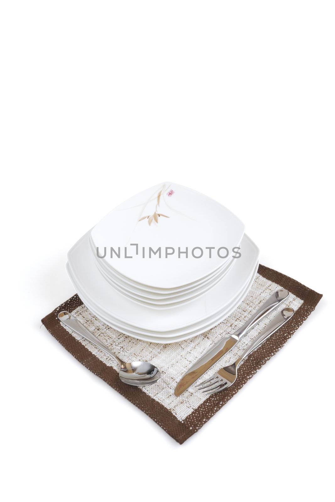 Table layout with tableware and a napkin on white background