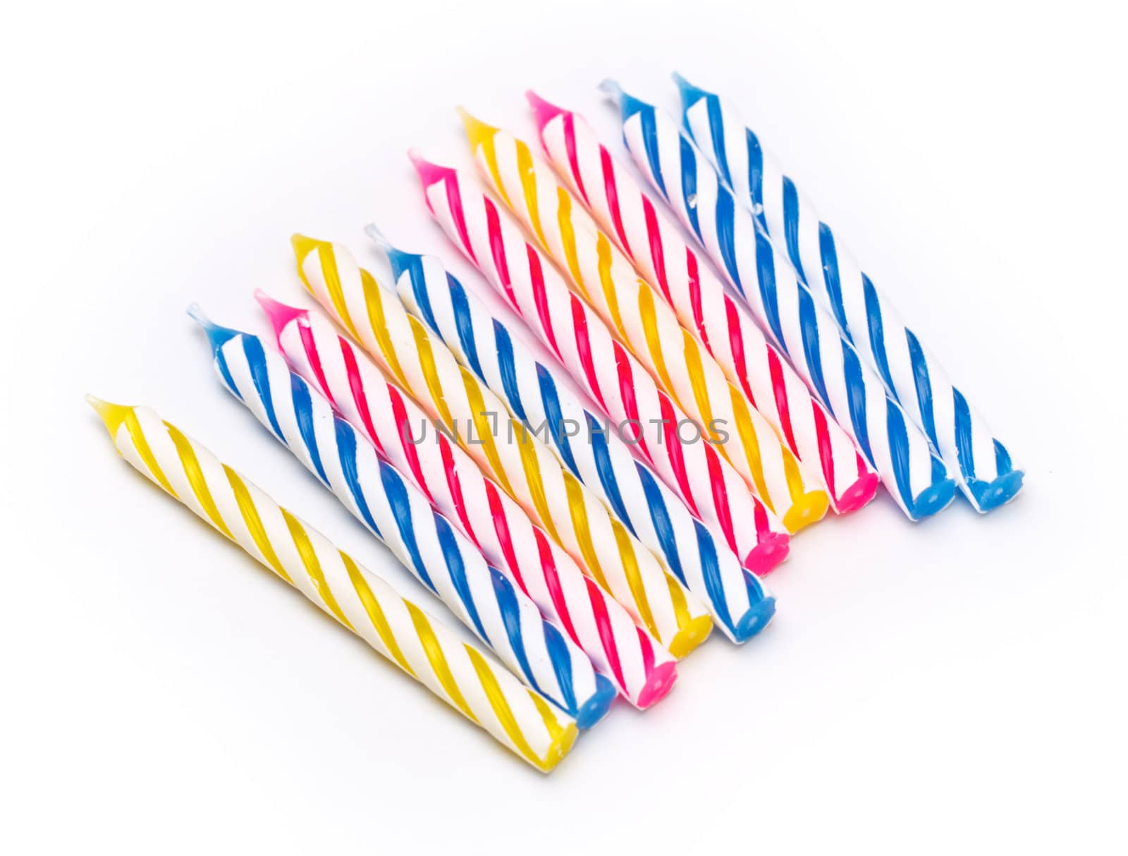 some striped birthday candles on white background