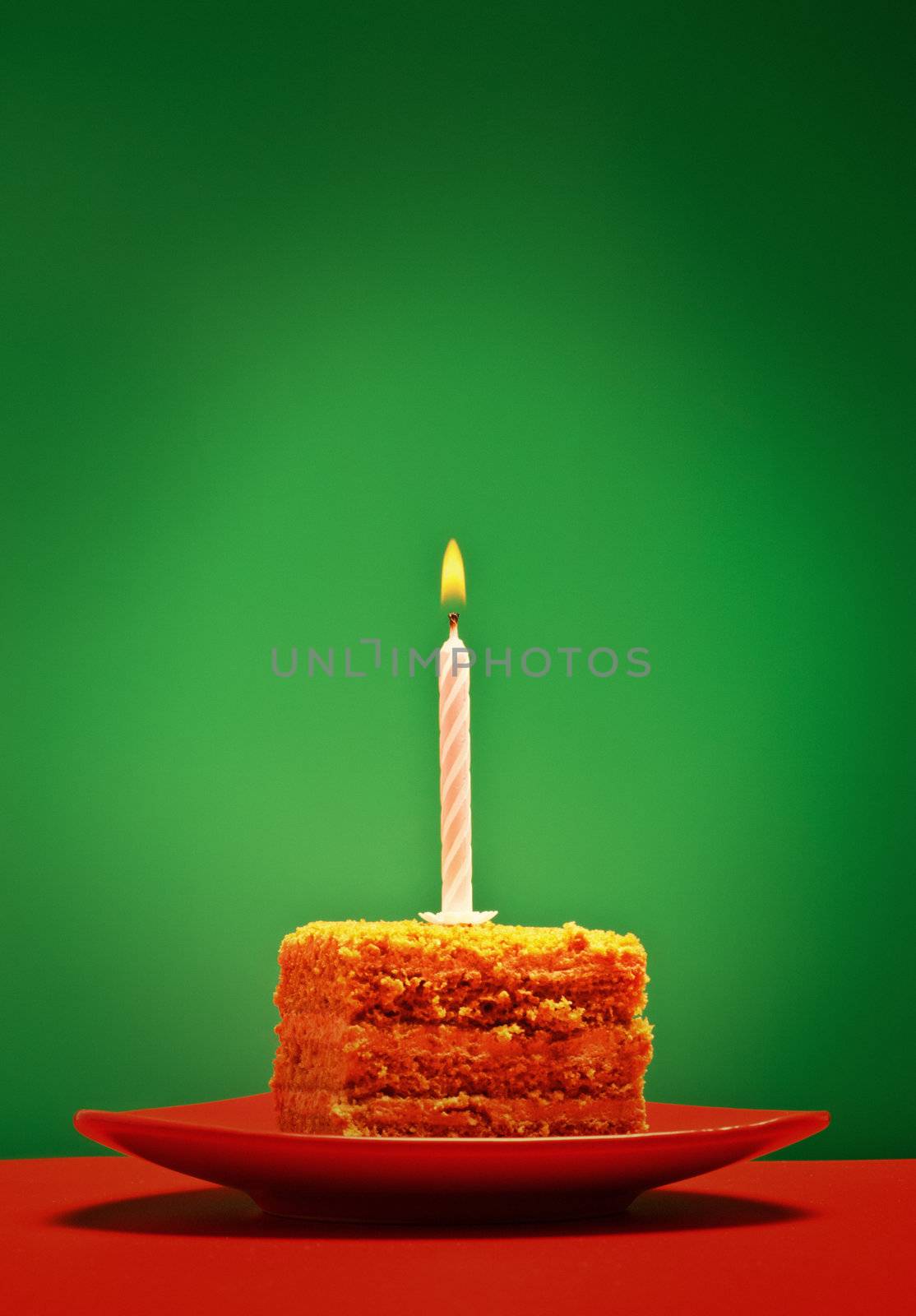 birthday cake with candle on pink background