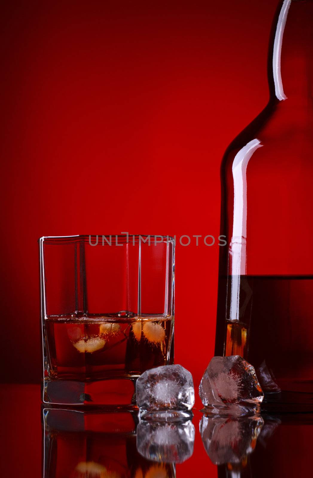 whiskey bottle and glass on red background