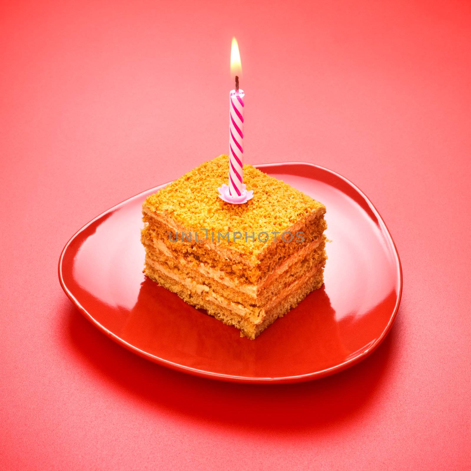 birthday cake with candle on pink background