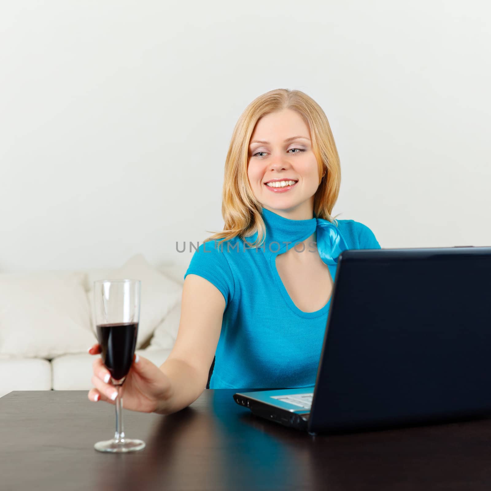 business woman celebrating with wine in front of her laptop
