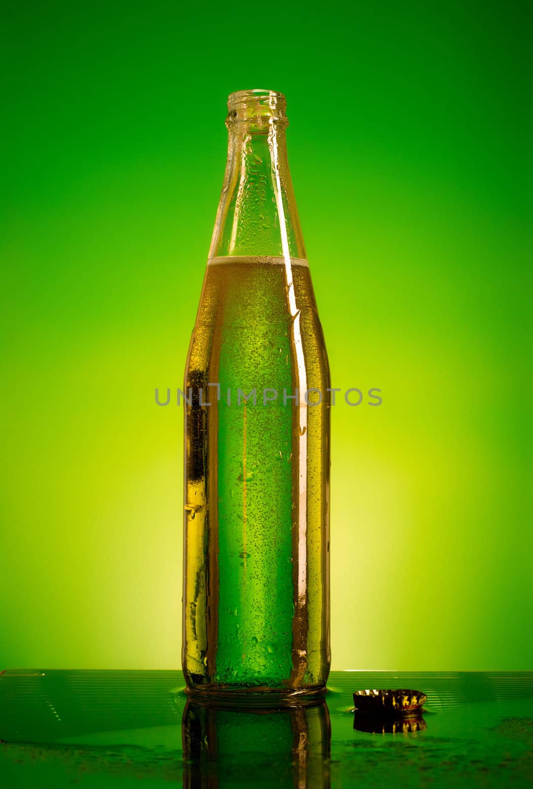 green soda bottle and ice cubes, green and yellow background