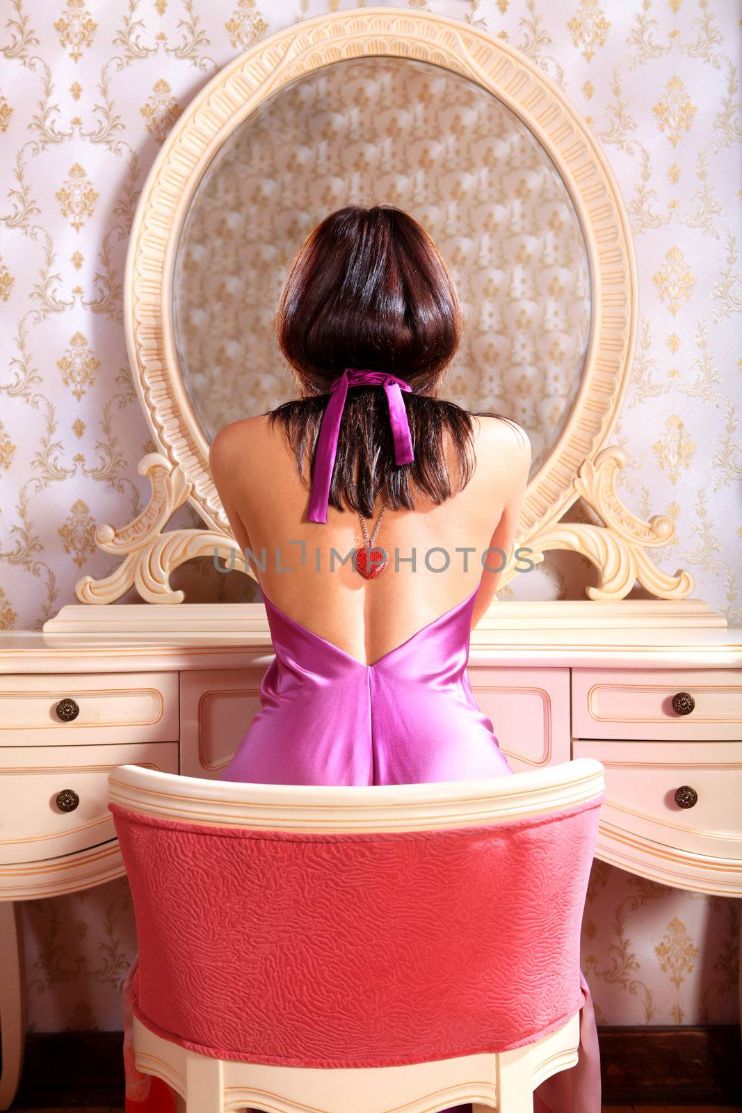 beautiful young lady at mirror admires reflexion in the bedroom