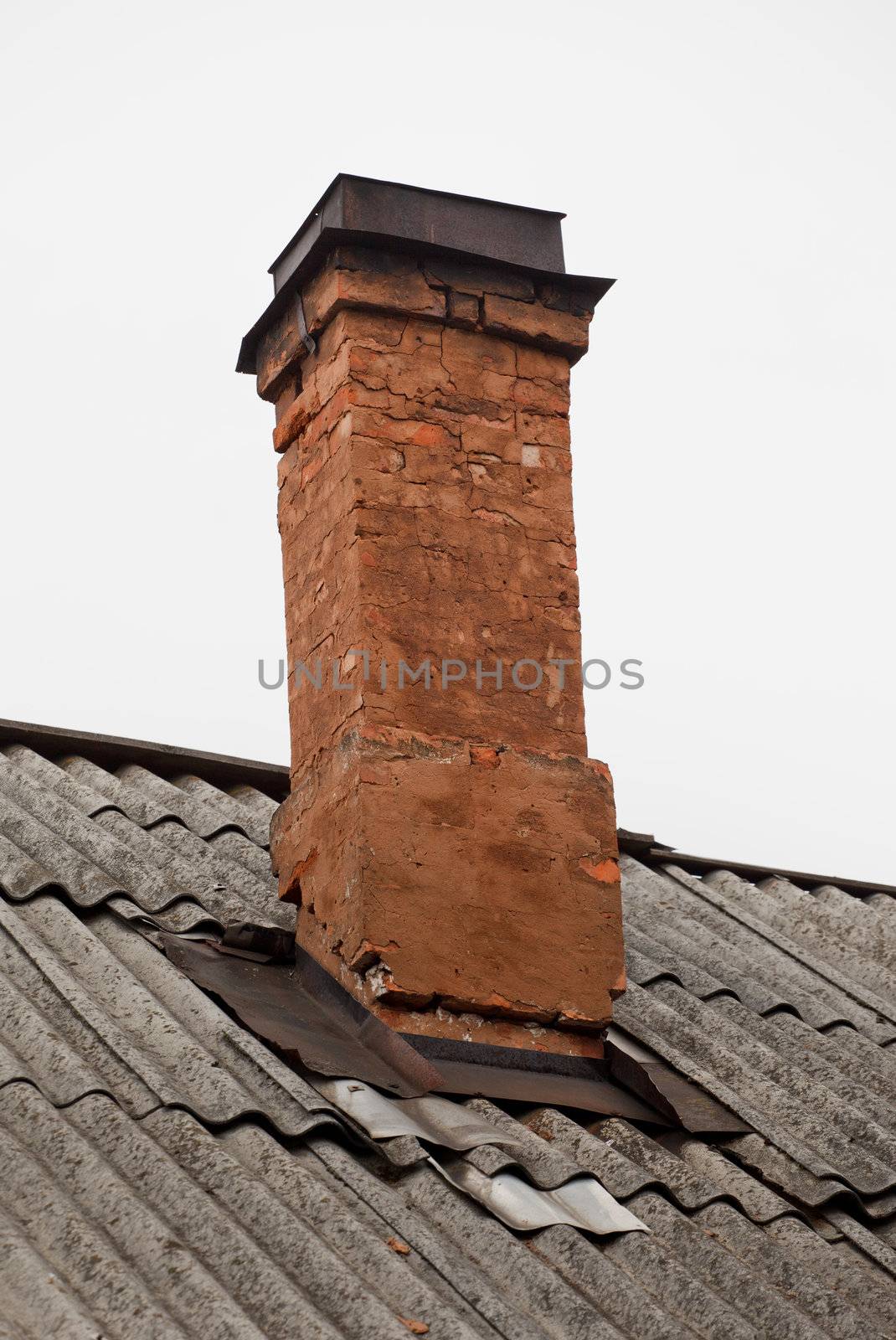 old brick chimney on roof against sky