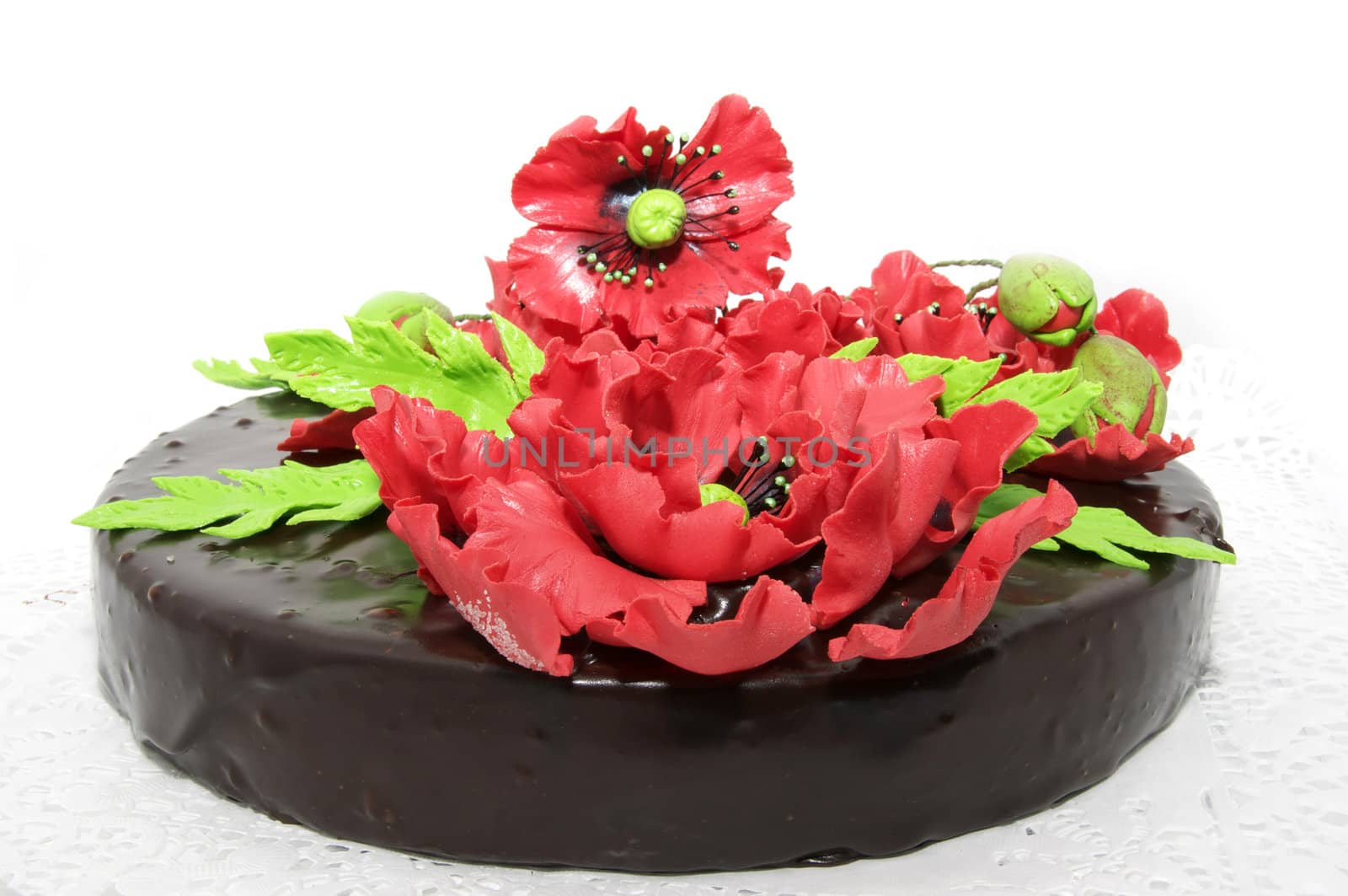 a large chocolate cake decorated with red flowers flowers