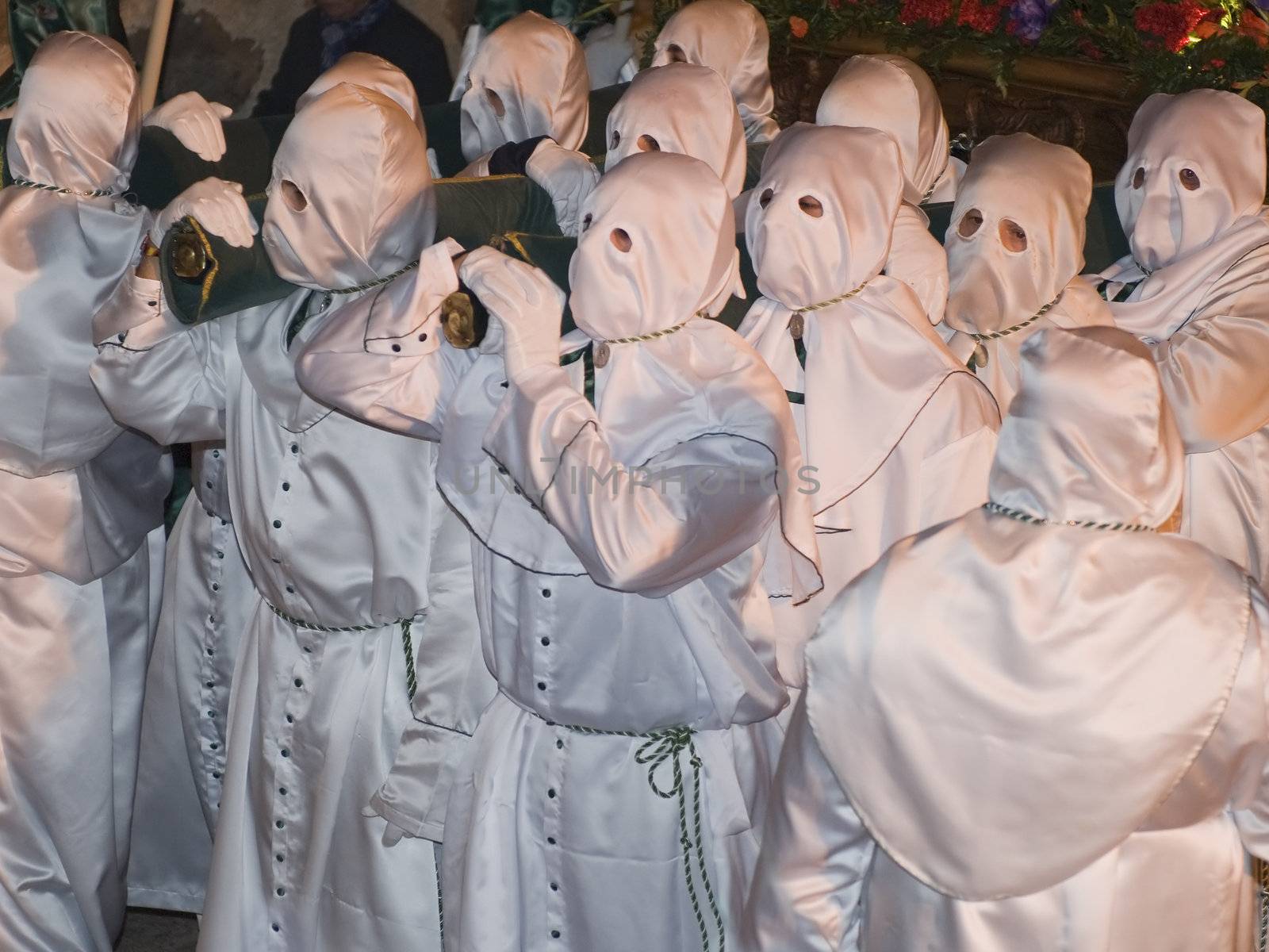 Easter nazarenes in white robe in a typical Spanish procession. 