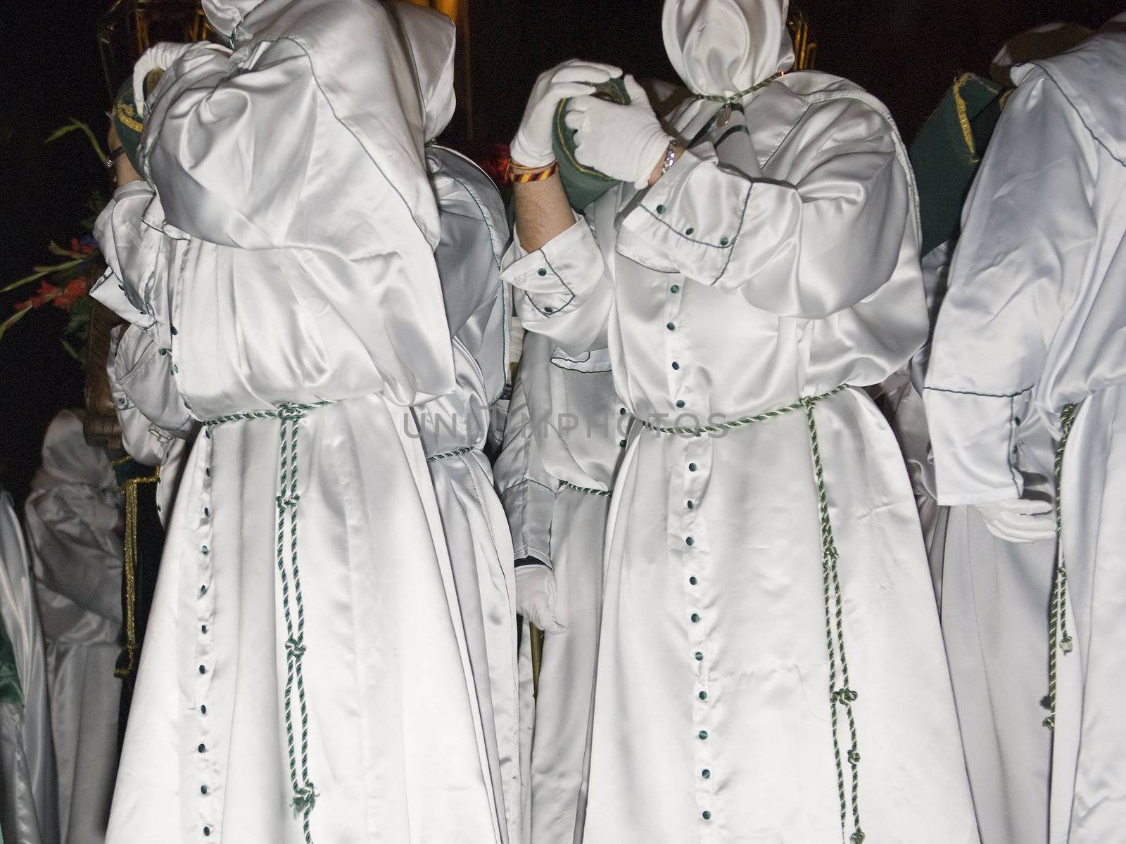 Easter nazarenes in white robe in a typical Spanish procession. 