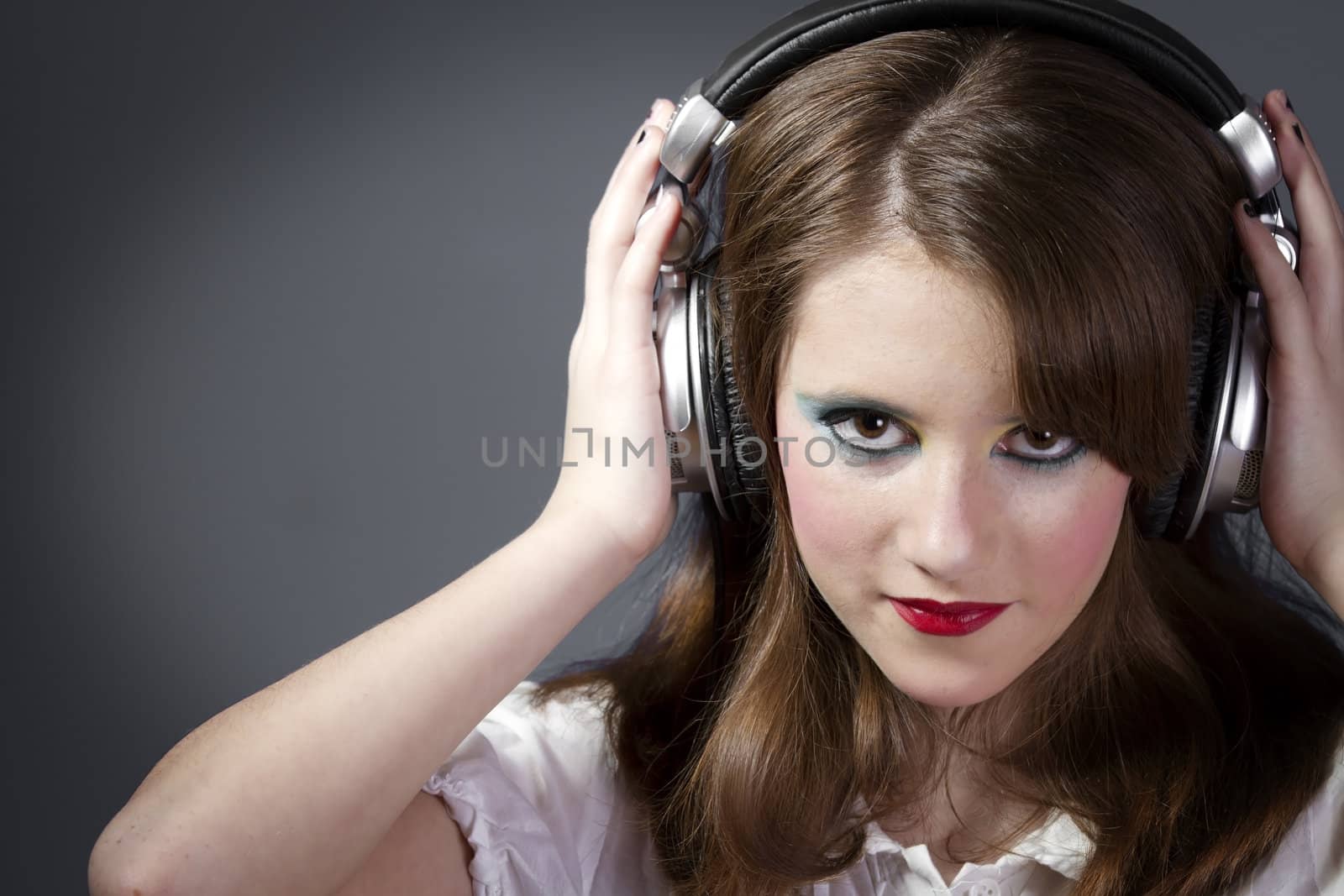 Beautiful Girl listening music over grey background
