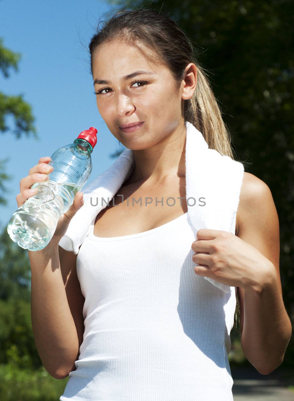 Young woman drinking water after exercise by adam121