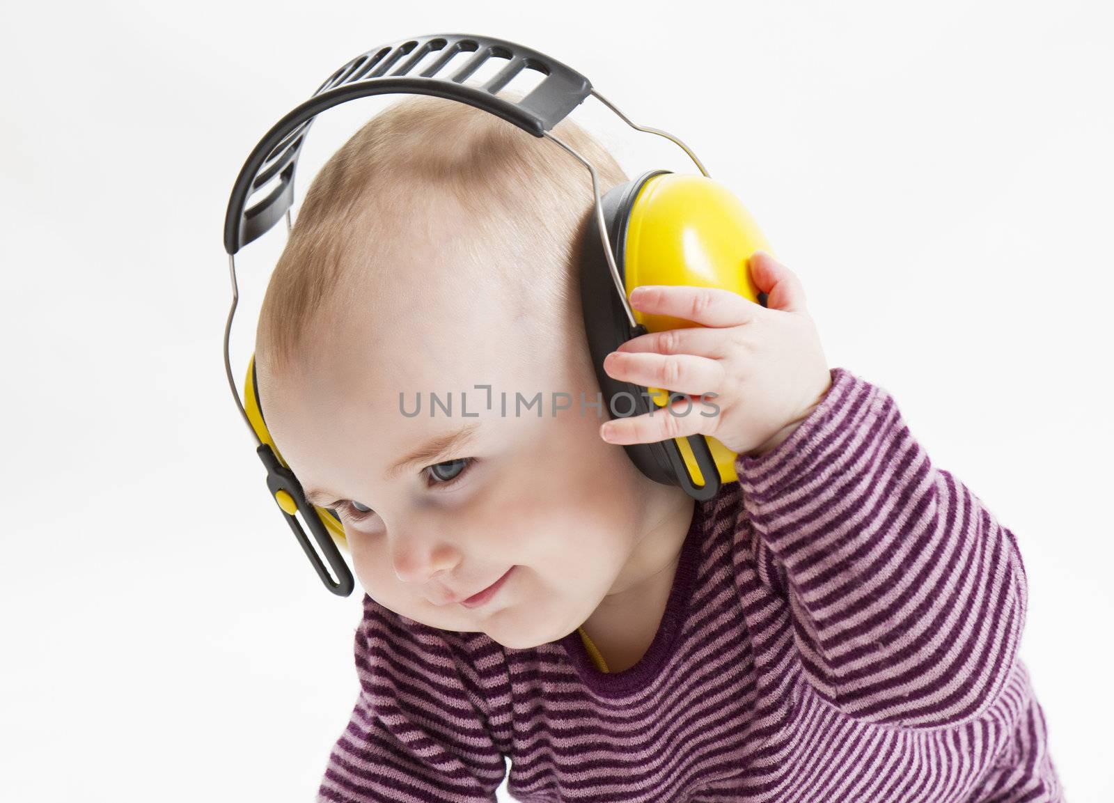 young satisfied child with yellow ear protector. hand is putting off the earmuffs
