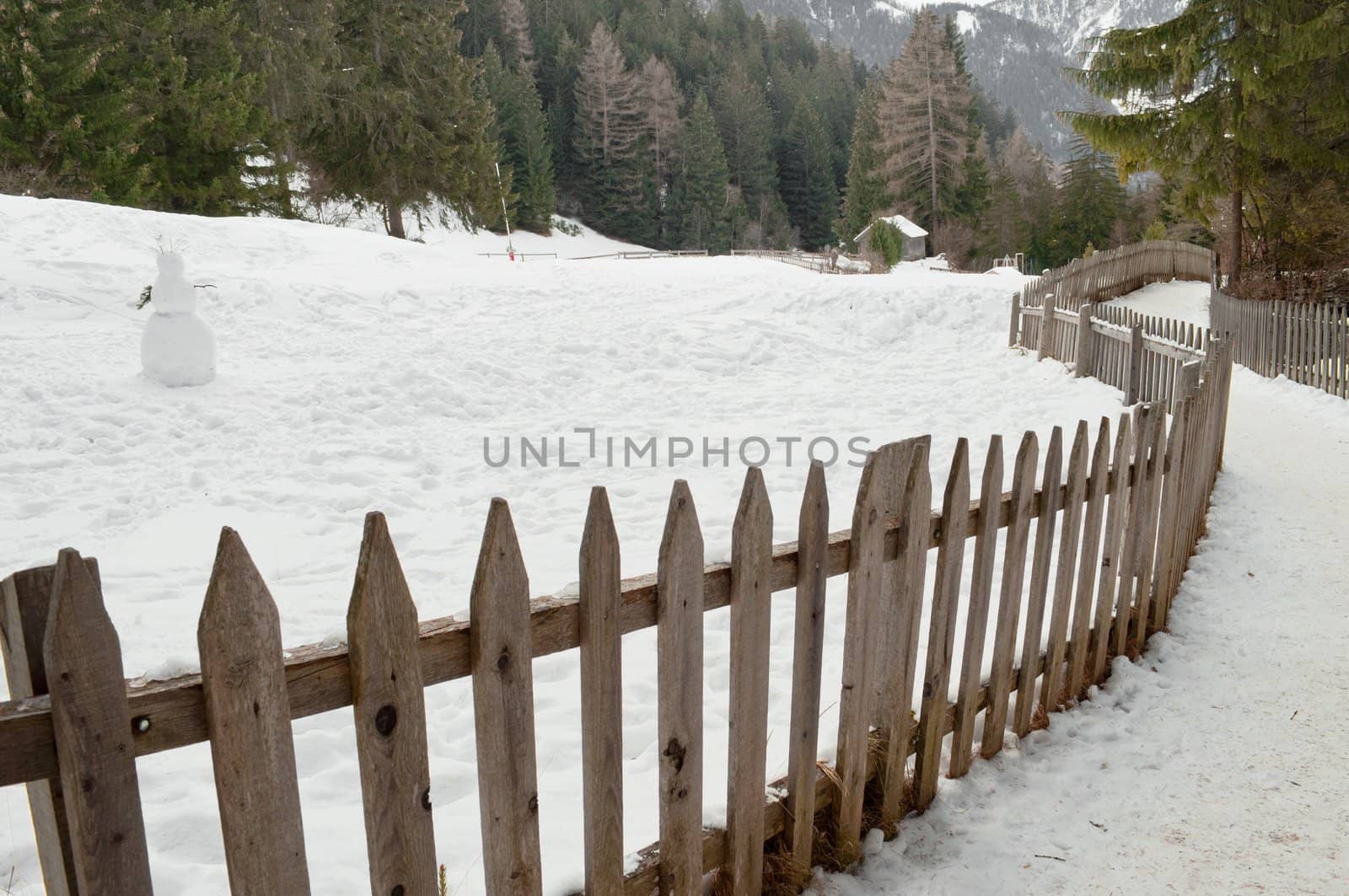 Winter landscape wooden fence in italian mountain