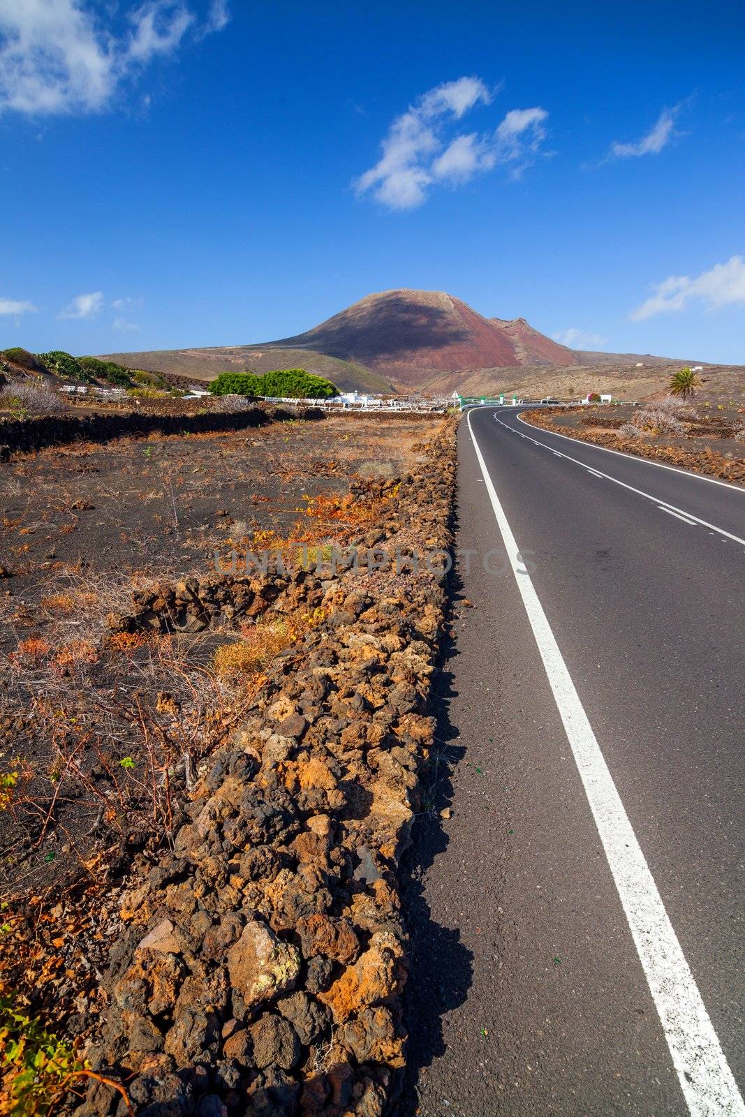 Empty road crossing the lava in the mountain, Lanzarote, Canary islands, Spain. Vertical view