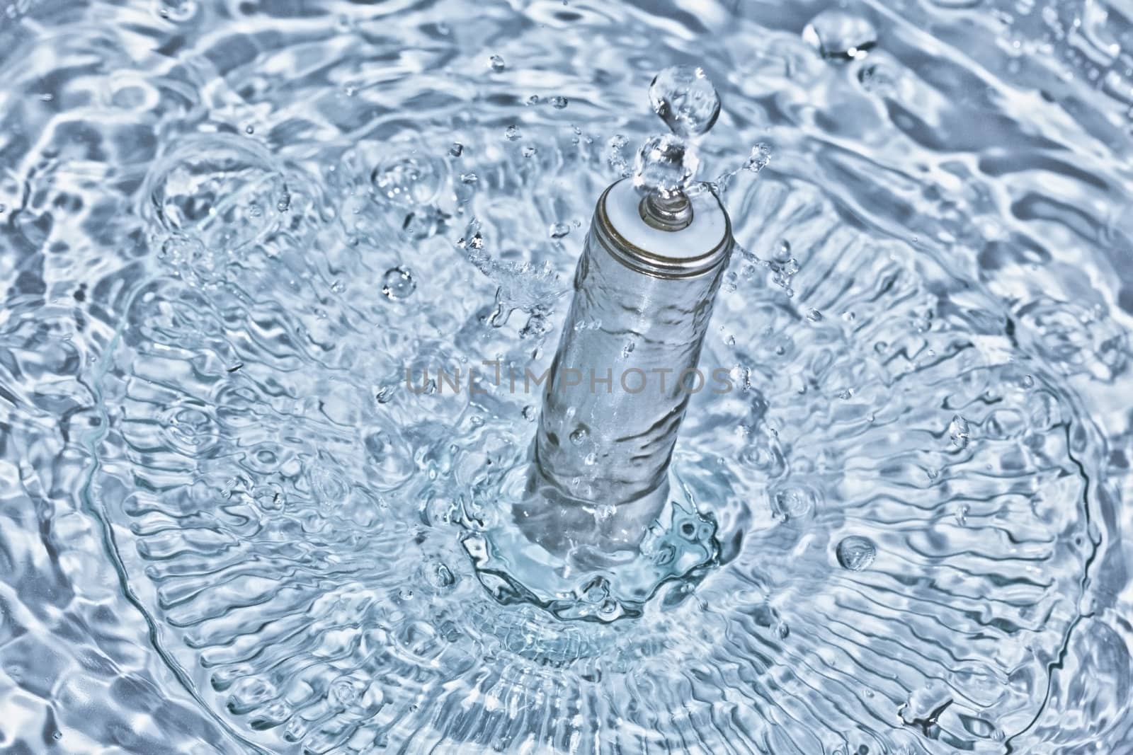 A rechargeable battery emerging out of crystal clear blue water