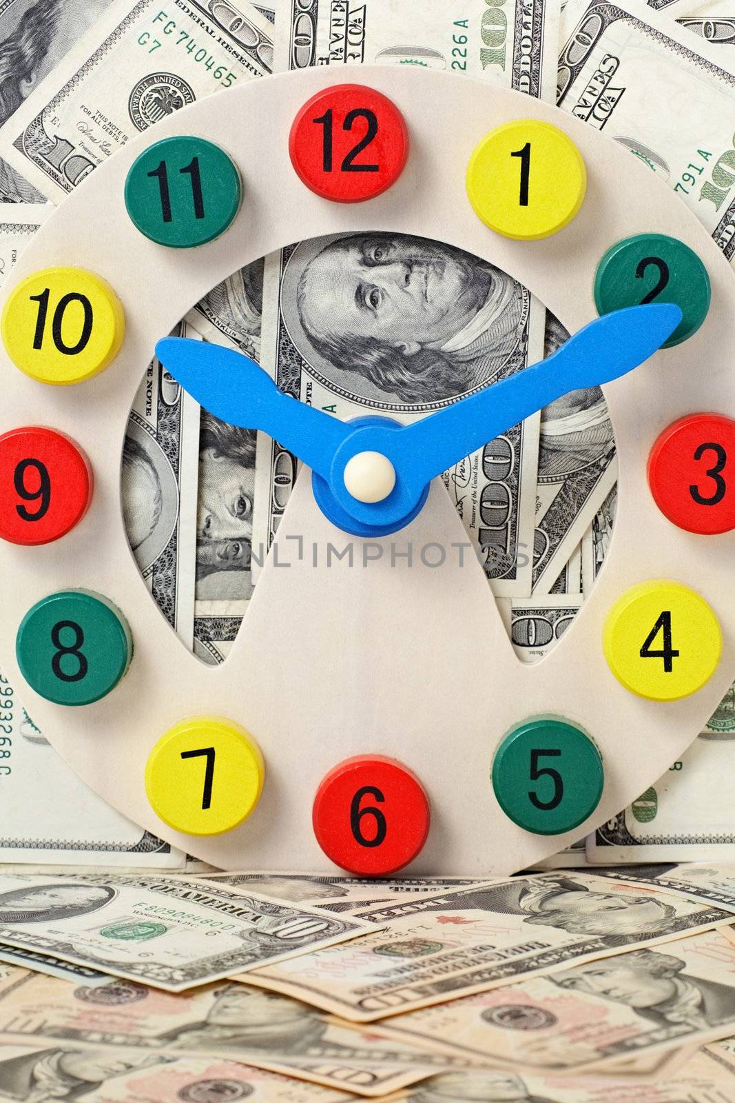 wooden clock on dollars background