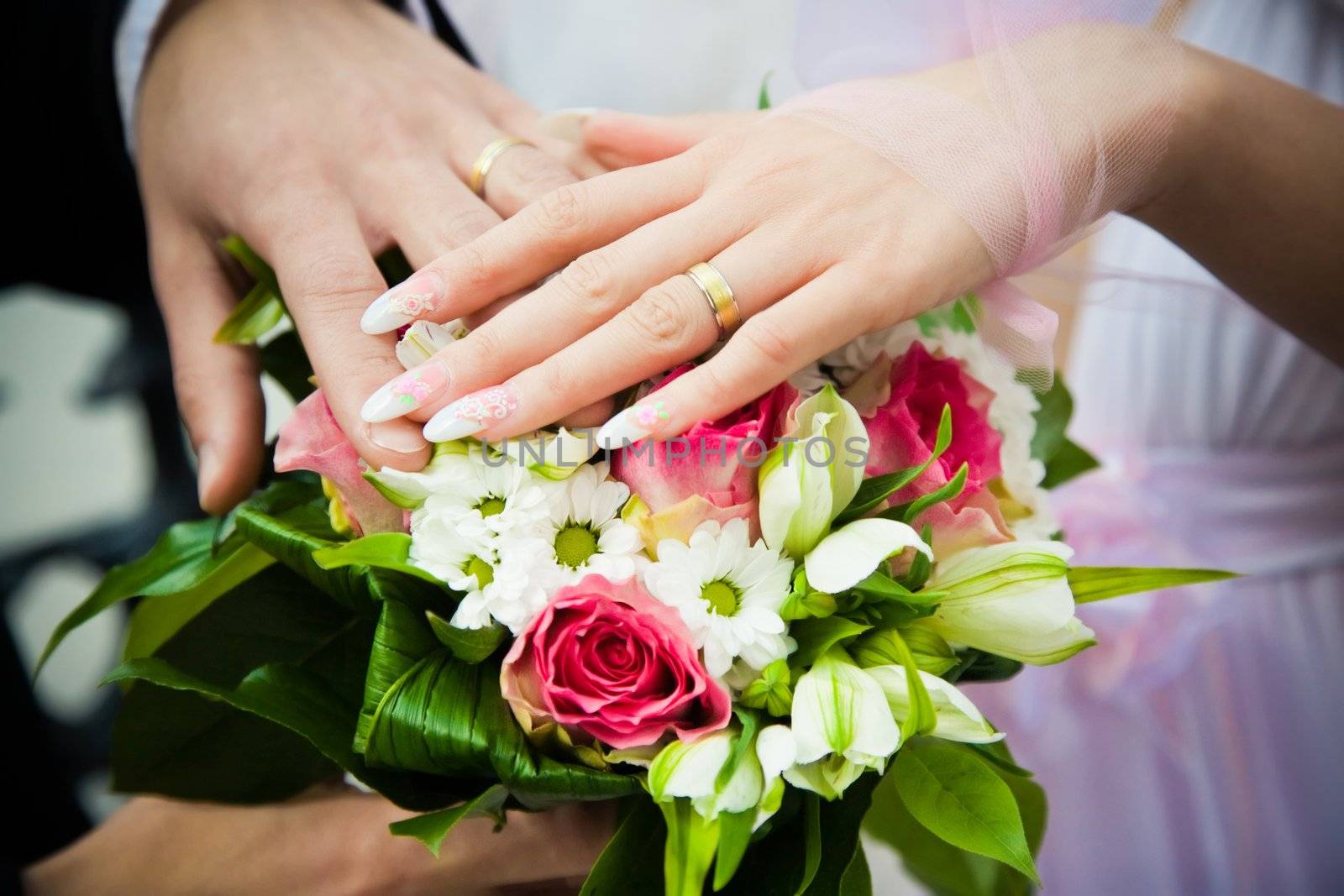 hands of newly married with wedding bouquet by zhu_zhu
