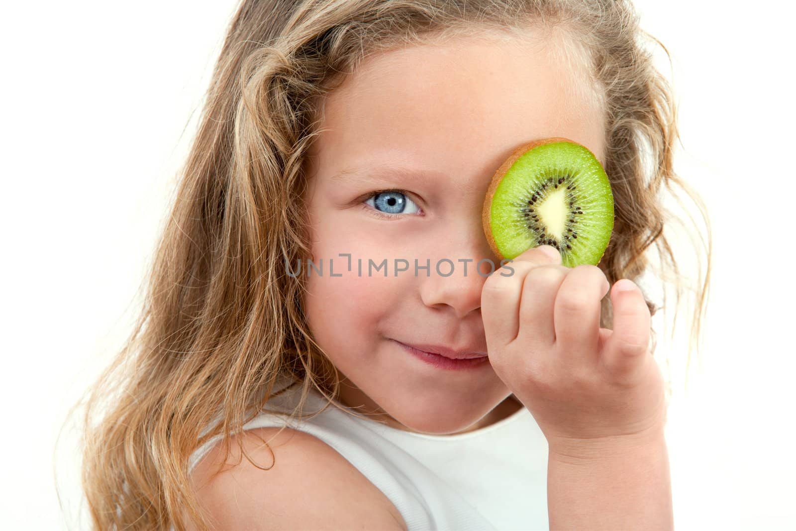 Close up Portrait of cute little girl holding fruit in front of eye. Isolated on white background.