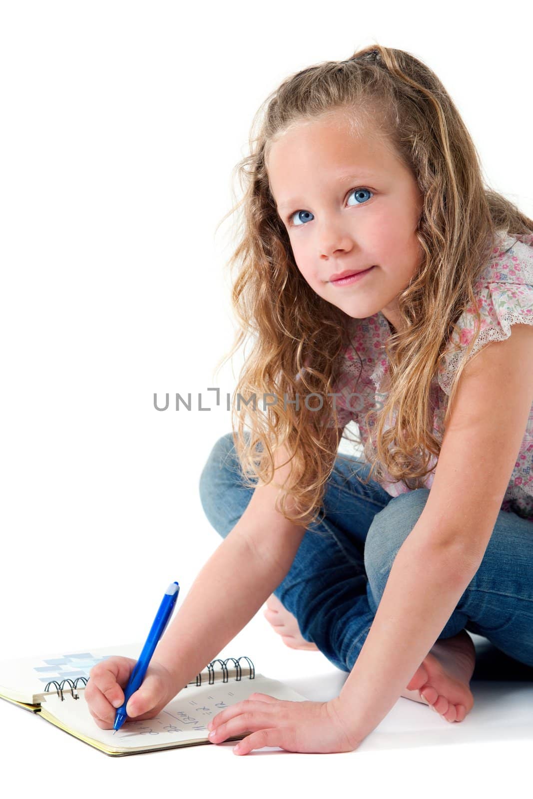 Portrait of cute blond girl doing homework. Isolated on white.