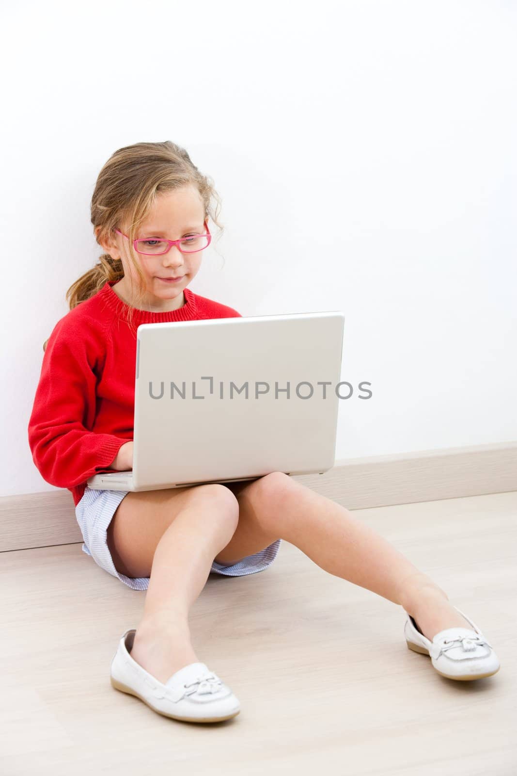 Young girl at home with laptop. by karelnoppe