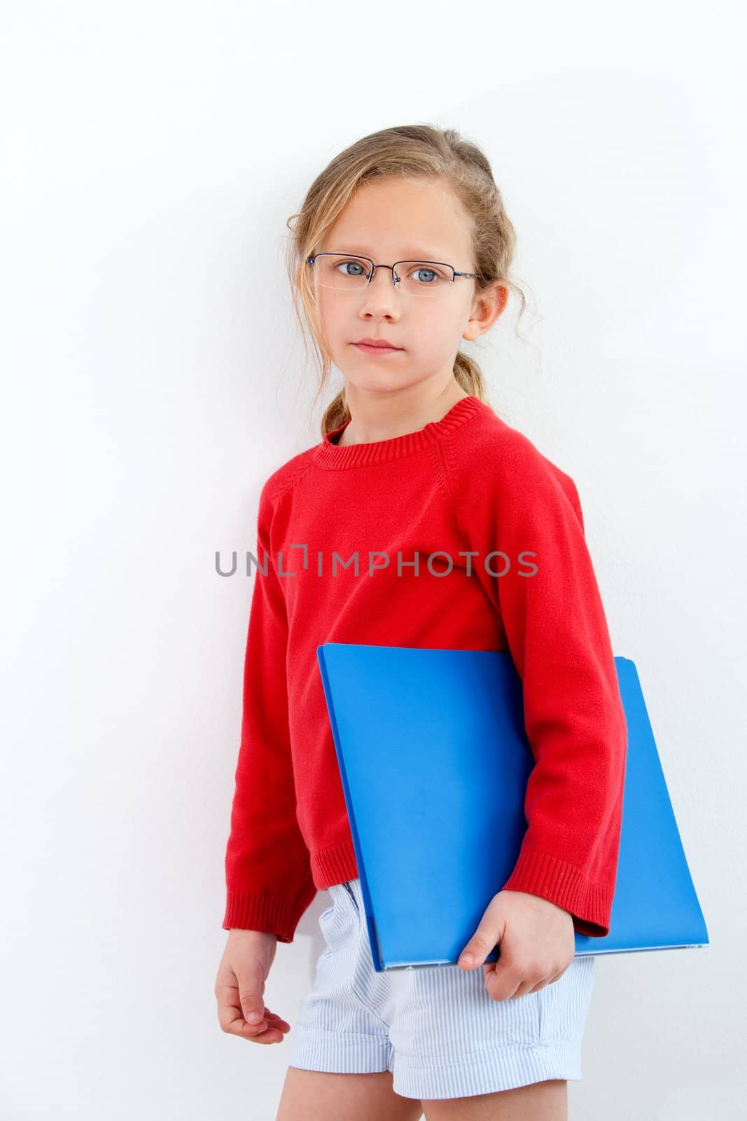 Portrait of cute blond girl holding blue notebook.