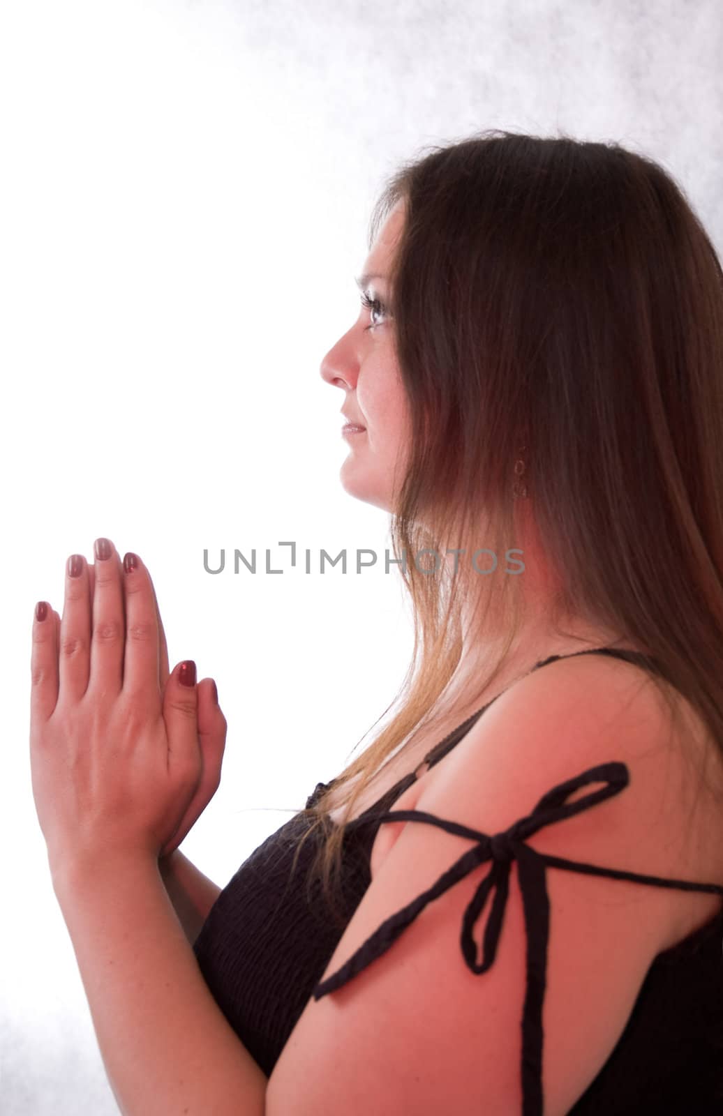 young woman with long brown hair praying to god