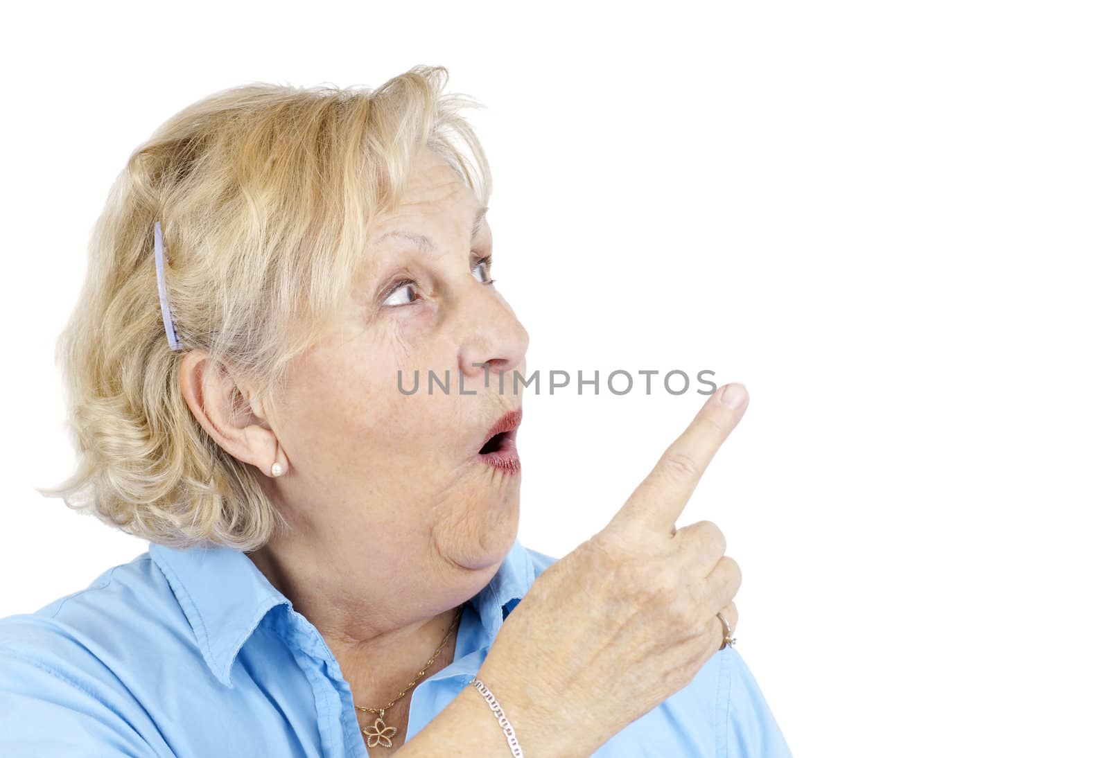 Funny senior woman with surprised face or in shock pointing with her finger at blank space beside her.