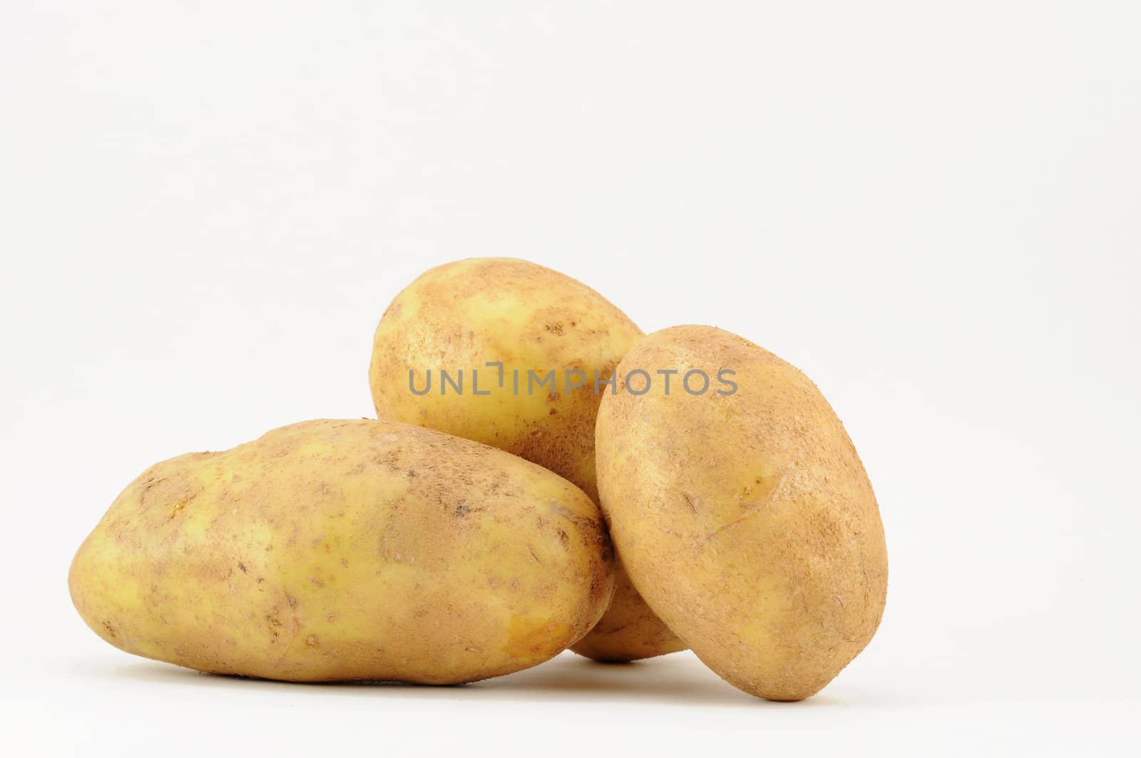 Trio of potatoes on white background with copy space.