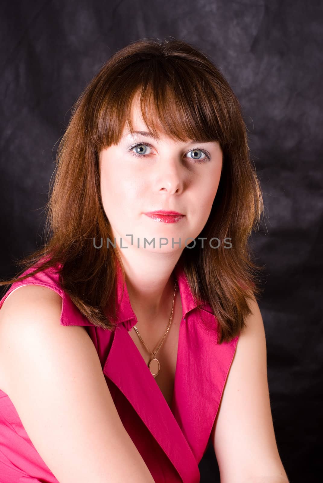 portrait of beautiful girl with brown hair and grey eyes on dark background