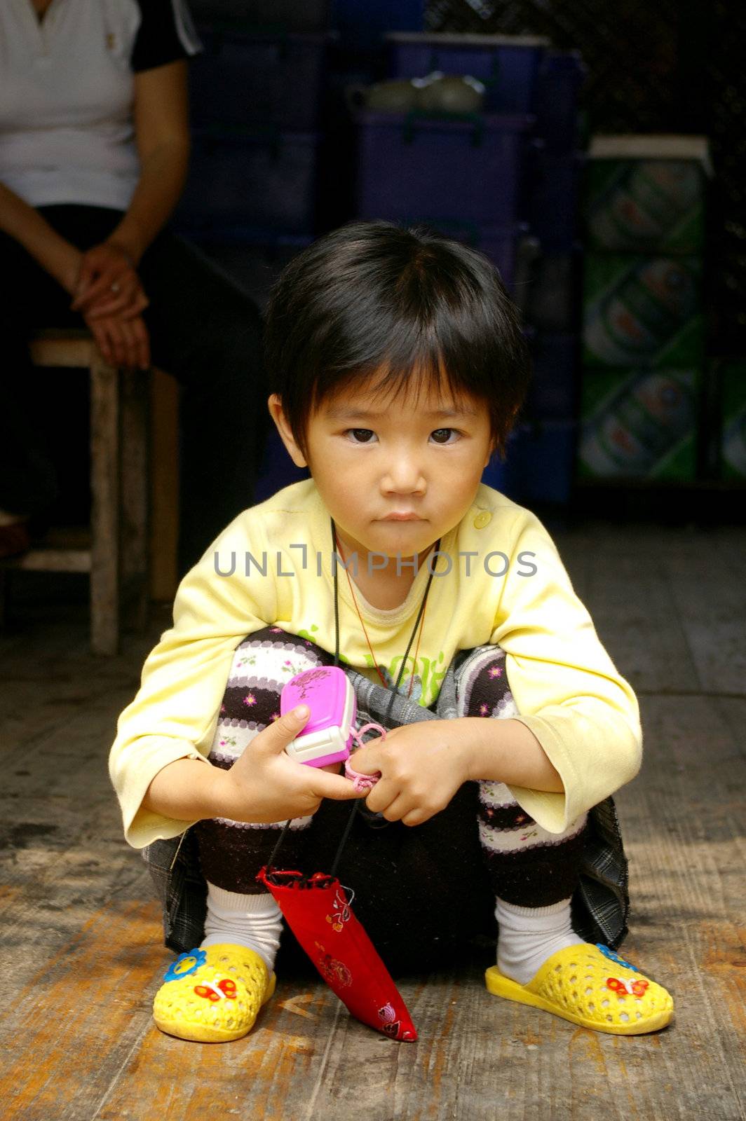 CHINA - MAY 16, A traditional Chinese young girl is sitting outside a shop on Yangshuo, China on 16 May, 2010.