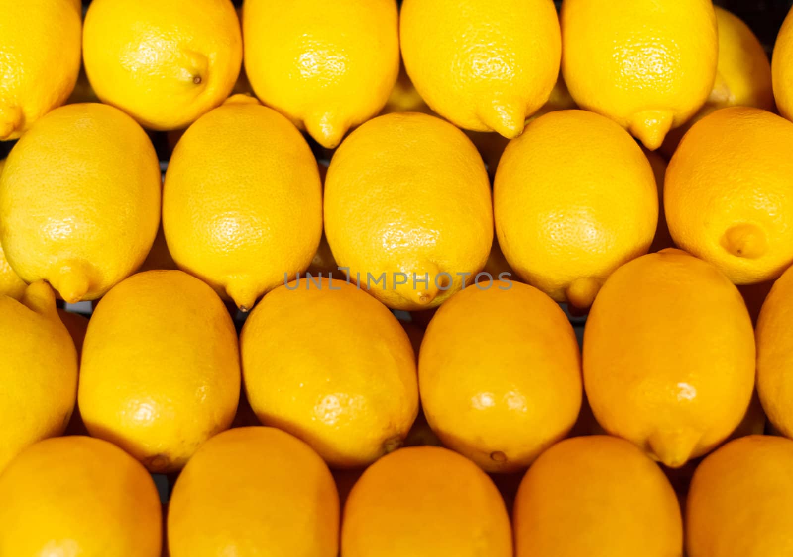 yellow background, texture of many lemons in market by ryhor