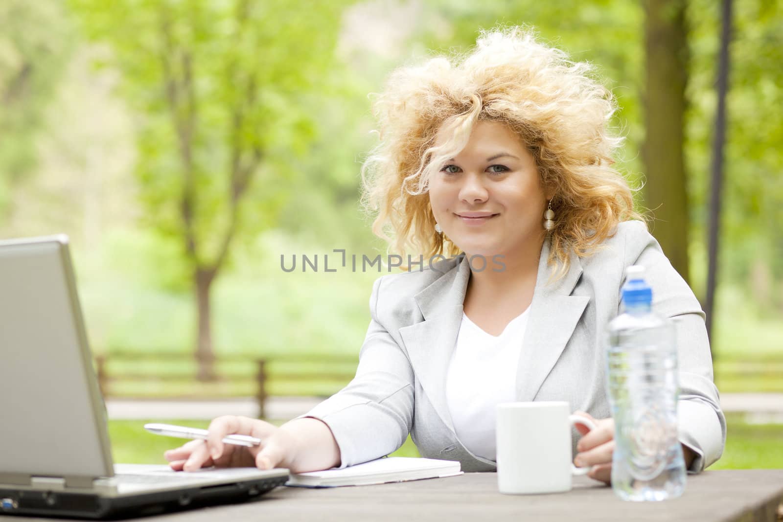 Woman using laptop in park by adamr