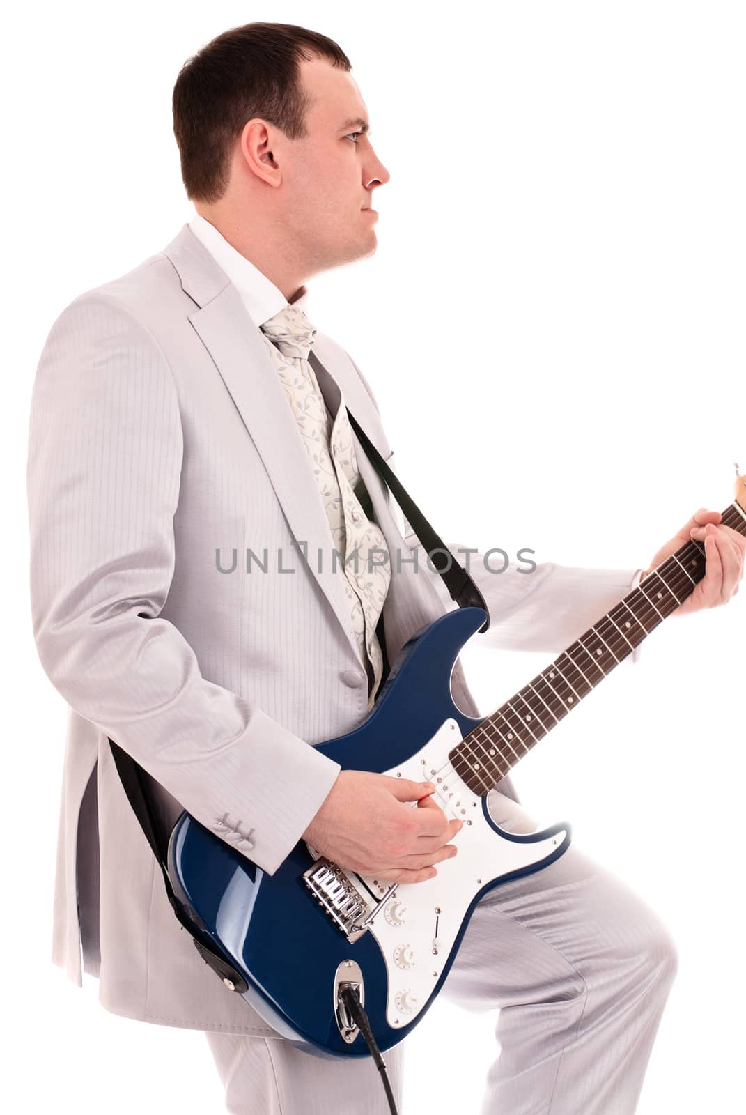 man in grey suit playing guitar, white background
