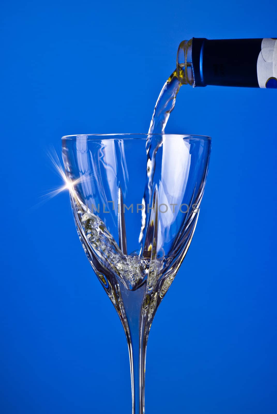 pouring wine into glass, blue background