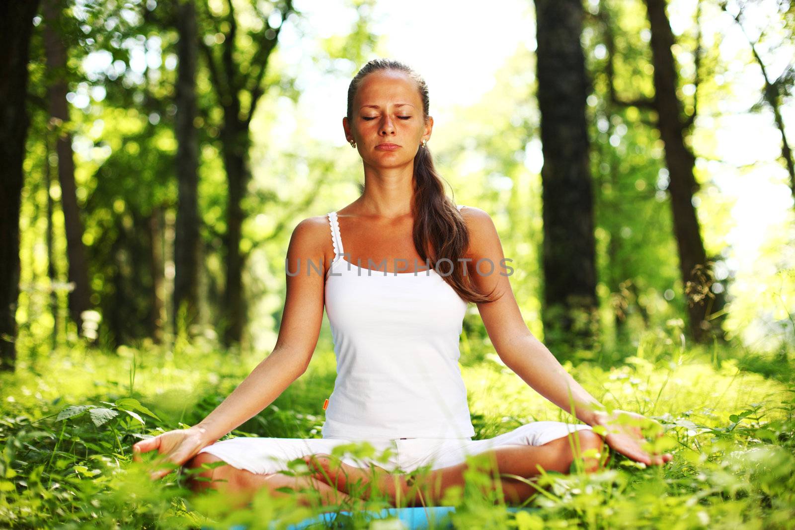 yoga woman on green grass in forest