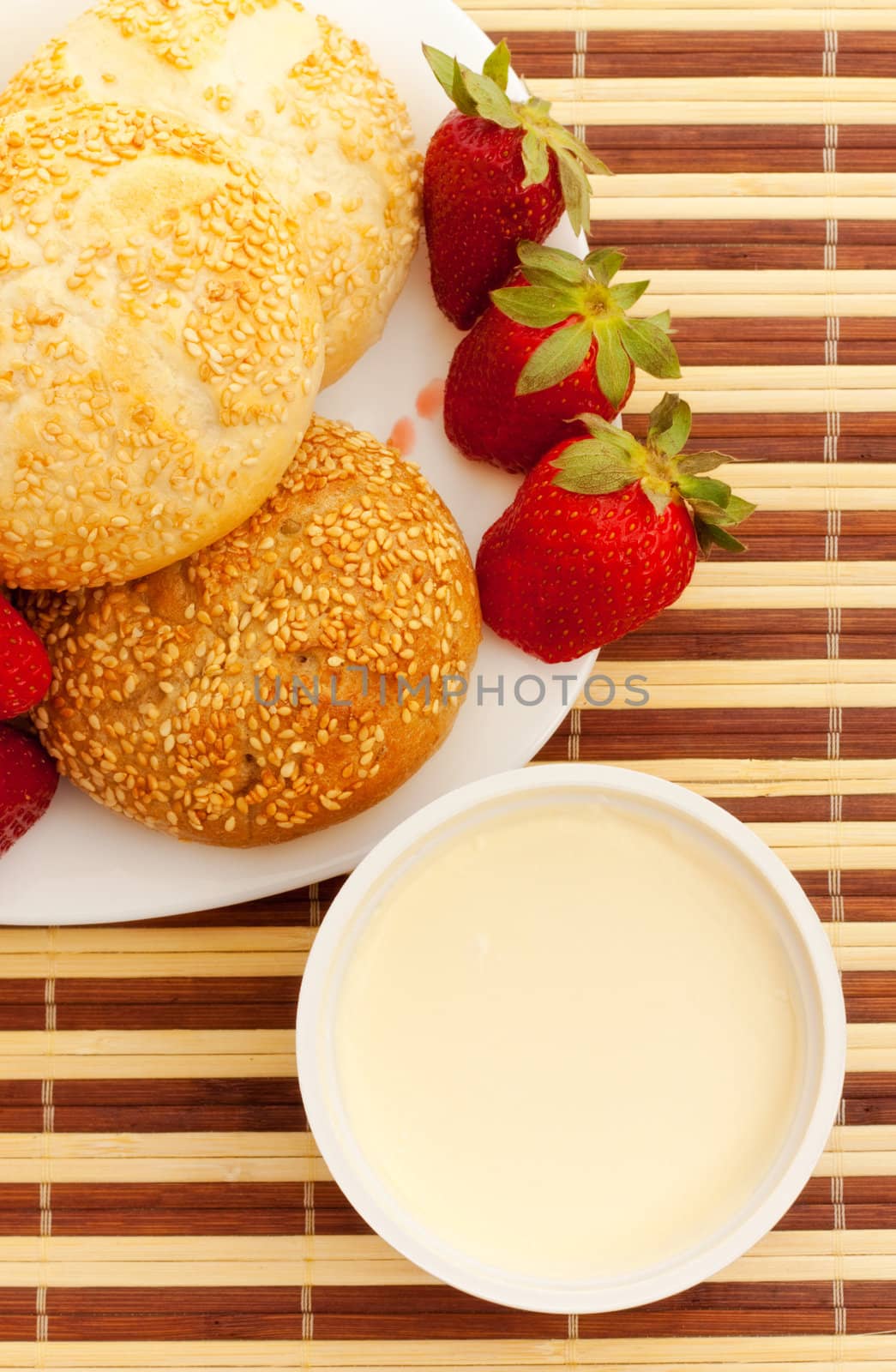 buns, strawberries and sour cream on table