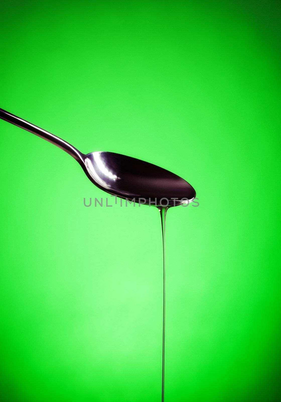 oil spill out of spoon, green background