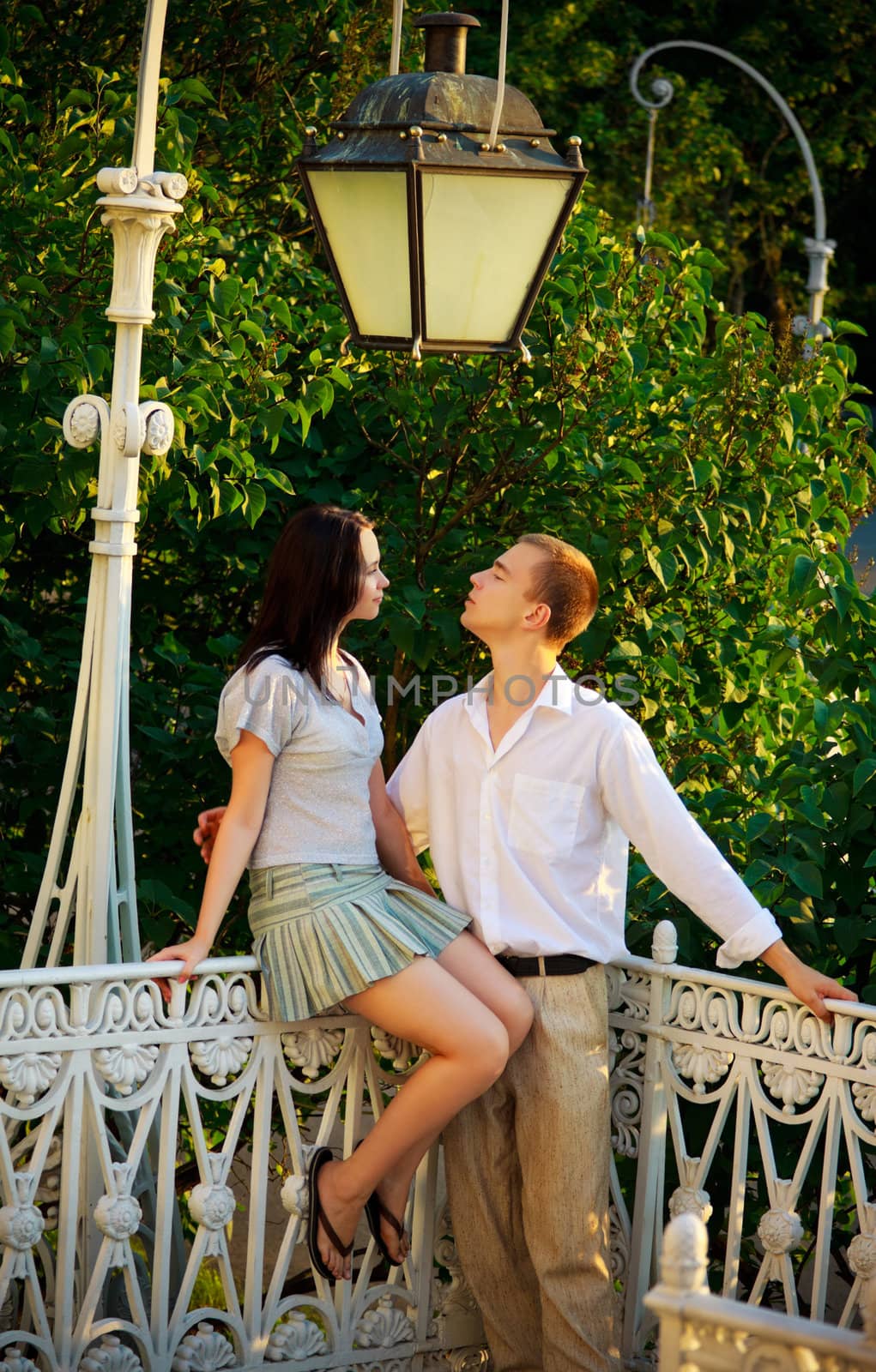 young couple in a park under old streetlamp
