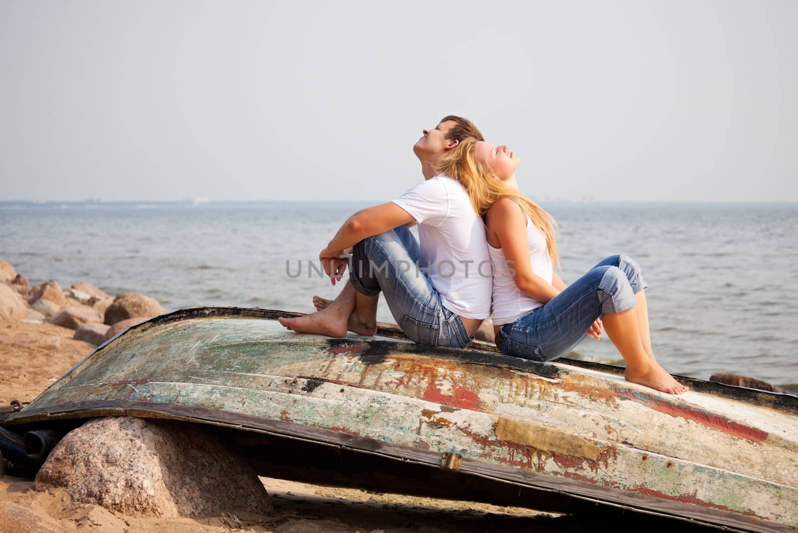 couple sitting on old boat back to back