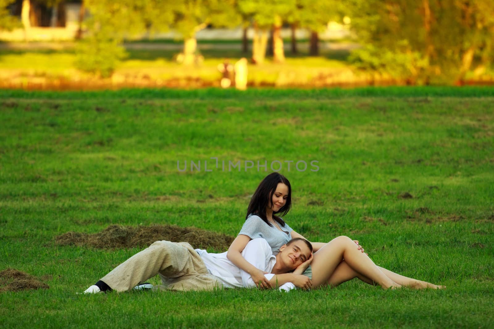 couple laying on park lawn by petr_malyshev