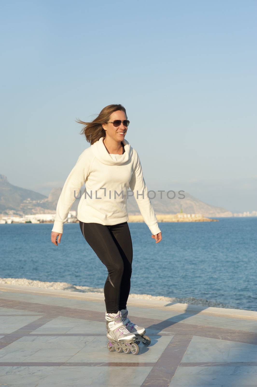 Woman skating along a sunny beach promenade