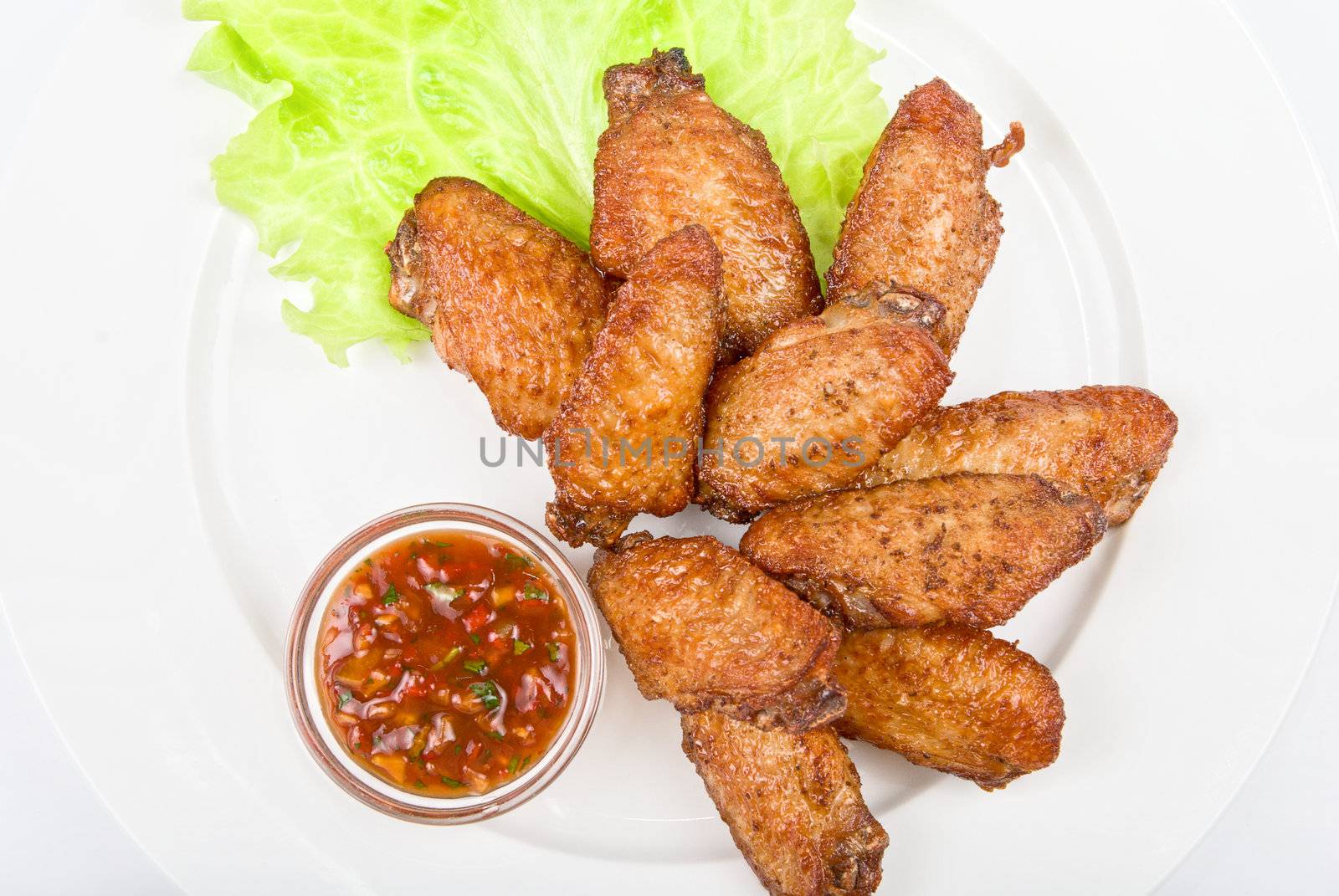 chicken roasted wing dish with sauce on a white background