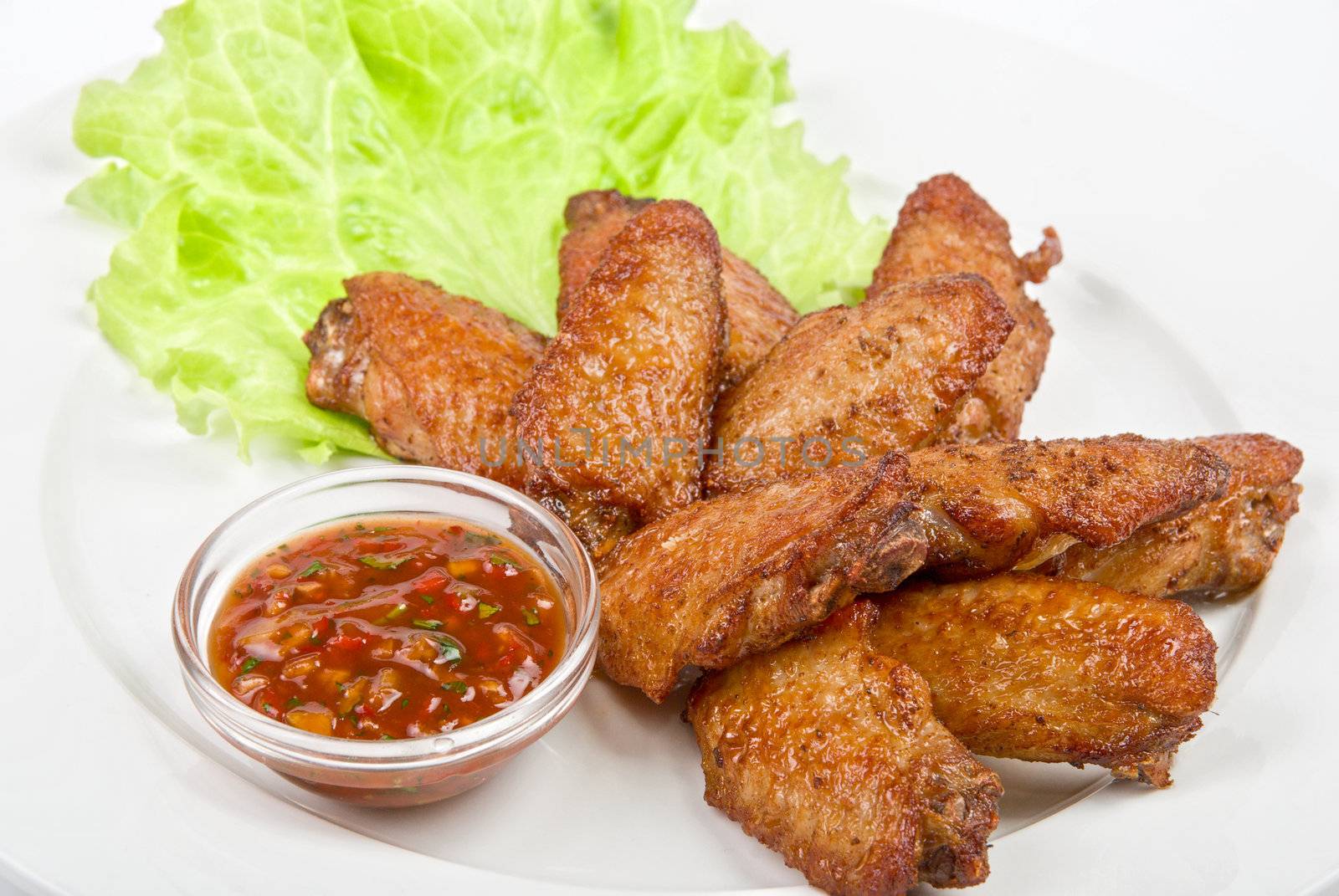 chicken roasted wing dish with sauce on a white background
