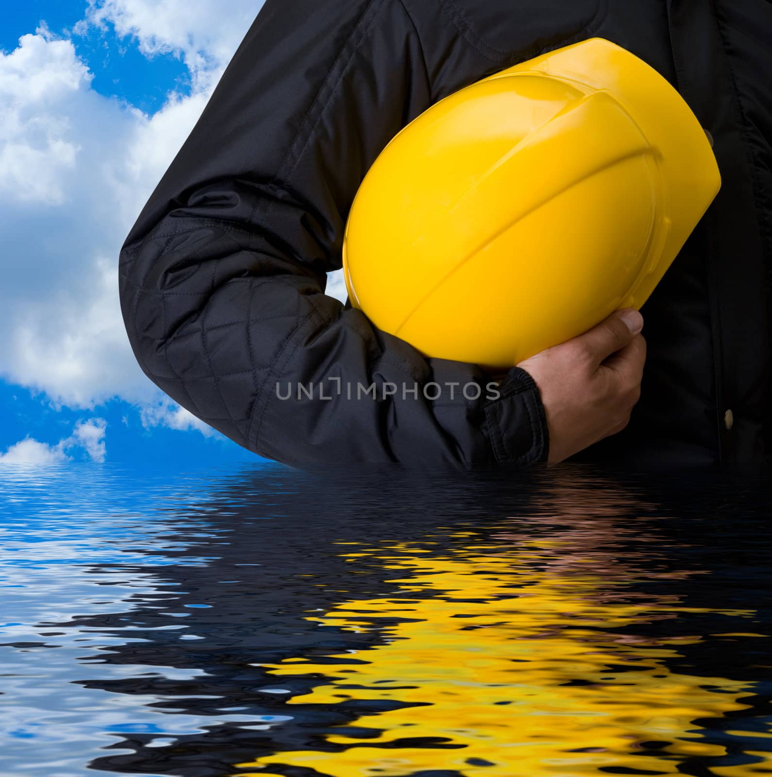 Closeup of Yellow helmet at builder hands on building background
