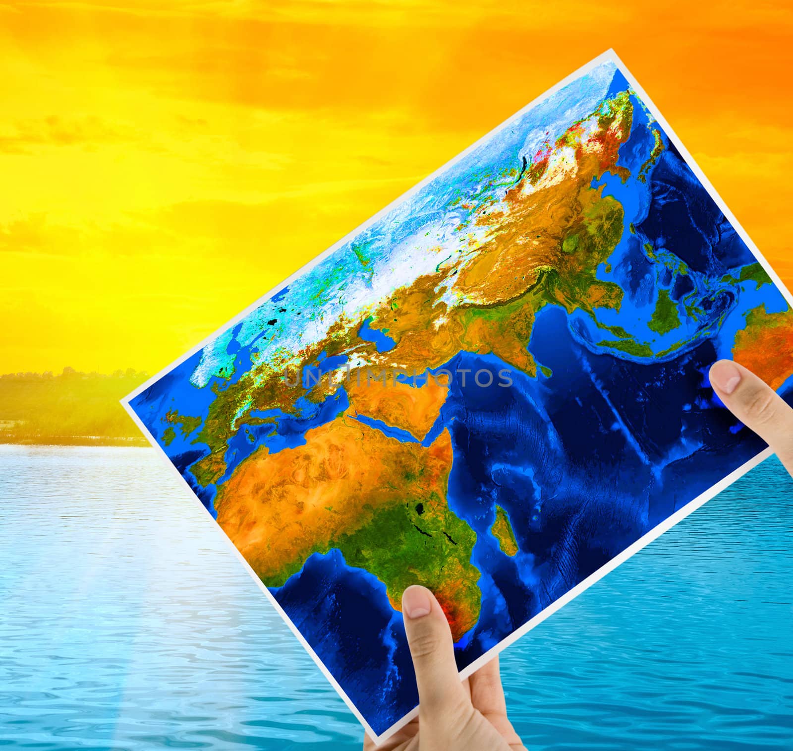 Hand holding map at beauty sunset on Lake, and orange sky