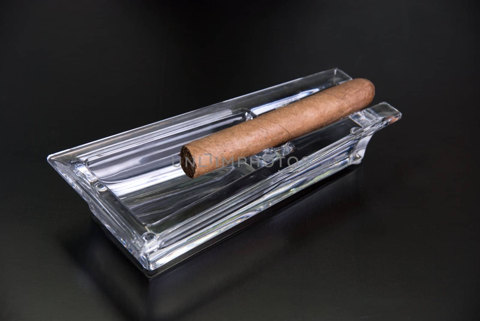 Cigar at ashtray isolated on a black back